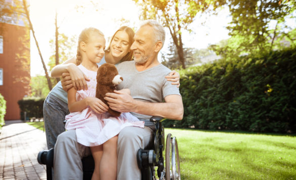 old man in wheelchair with family